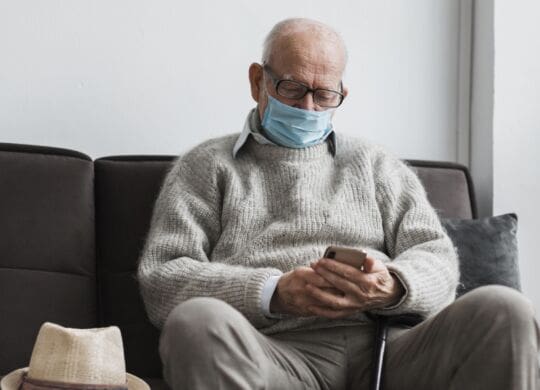old-man-with-medical-mask-in-a-nursing-home-using-smartphone